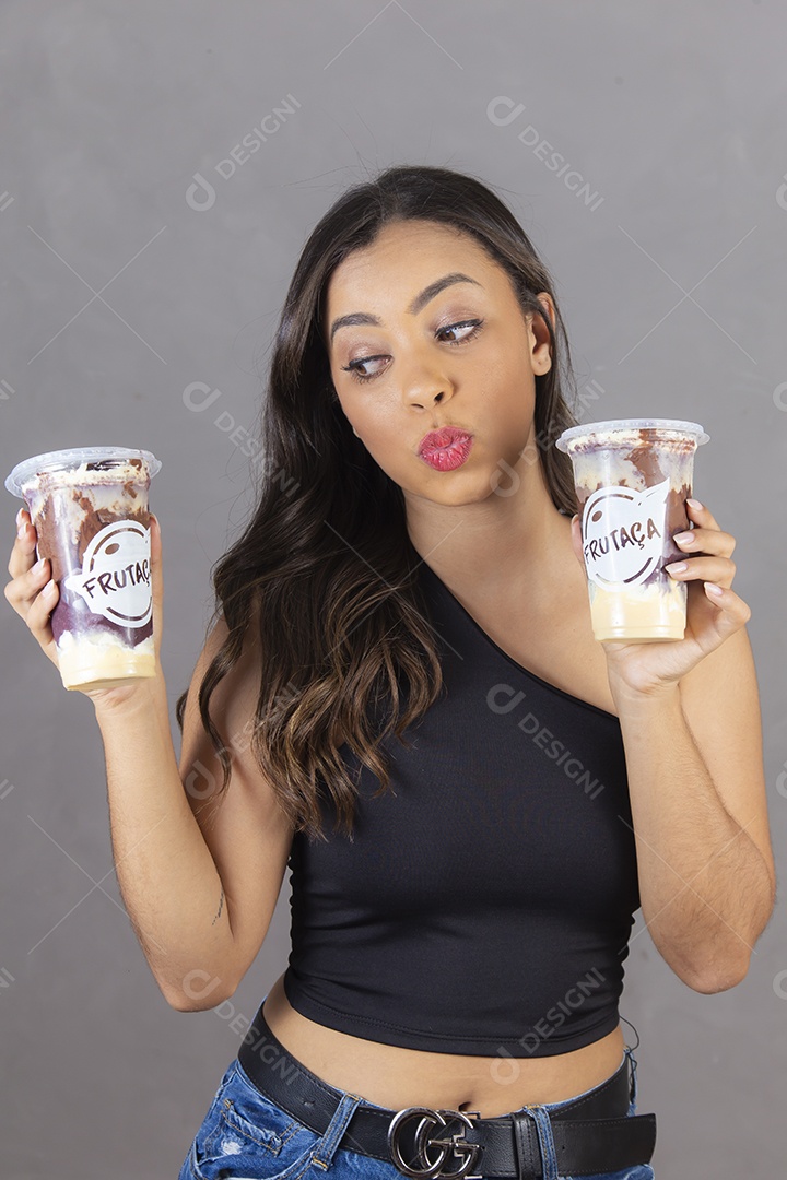 Mulher jovem sorridente segurando copos da felicidade