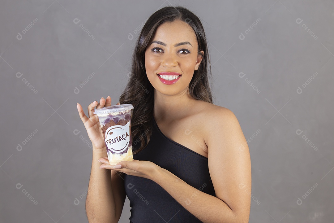 Mulher jovem sorridente segurando um copo da felicidade