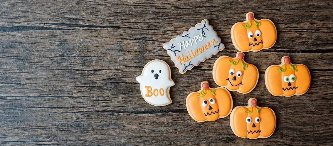 Feliz dia de Halloween com biscoitos engraçados na mesa de madeira background