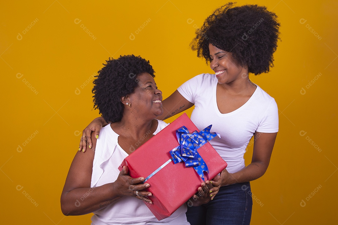 Mulheres negras mãe e filha vestidas com blusa branca com gestos de carinho