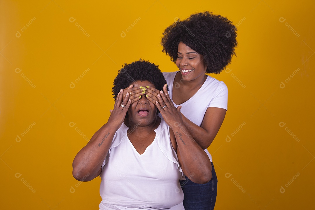 Mulheres negras mãe e filha vestidas com blusa branca com gestos de carinho