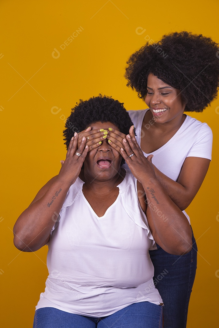 Mulheres negras mãe e filha vestidas com blusa branca com gestos de carinho