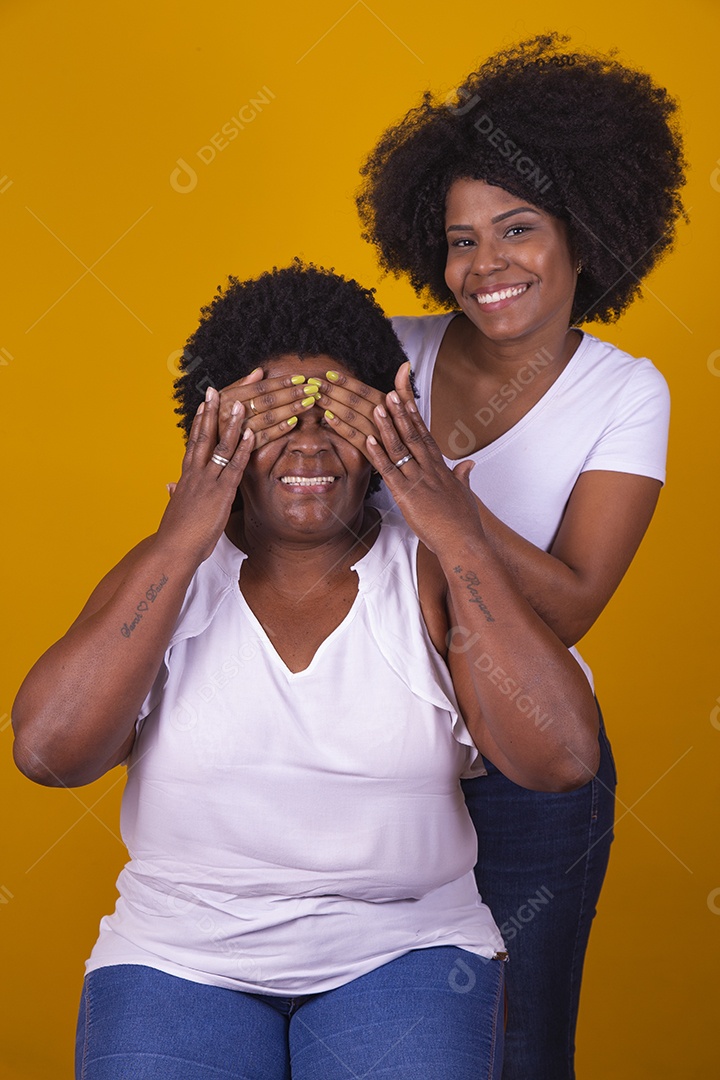 Mulheres negras mãe e filha vestidas com blusa branca com gestos de carinho