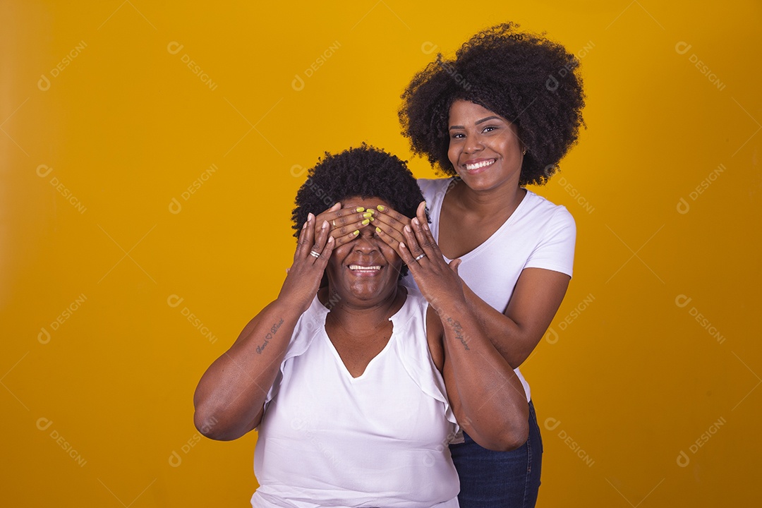 Mulheres negras mãe e filha vestidas com blusa branca com gestos de carinho
