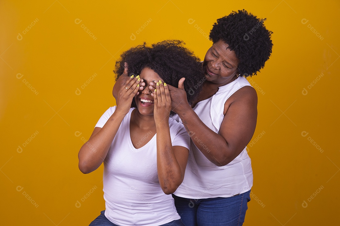 Mulheres negras mãe e filha vestidas com blusa branca com gestos de carinho