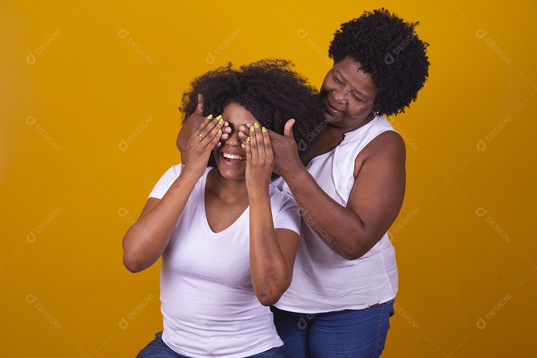 Mulheres negras mãe e filha vestidas com blusa branca com gestos de carinho