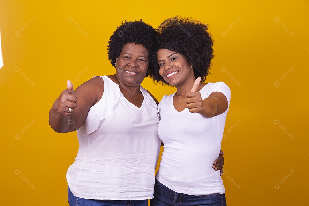 Mulheres negras mãe e filha vestidas com blusa branca com gestos de carinho