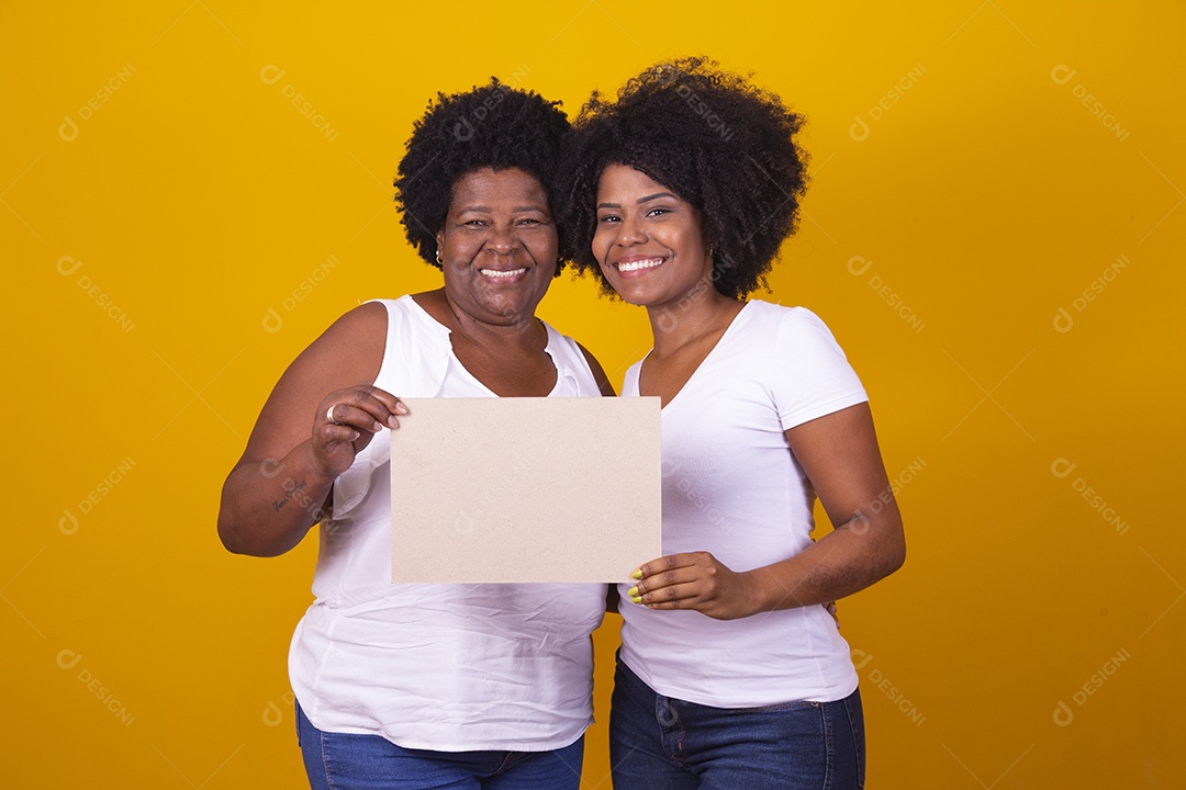 Mulheres negras mãe e filha vestidas com blusa branca com gestos de carinho segurando cartaz em branco