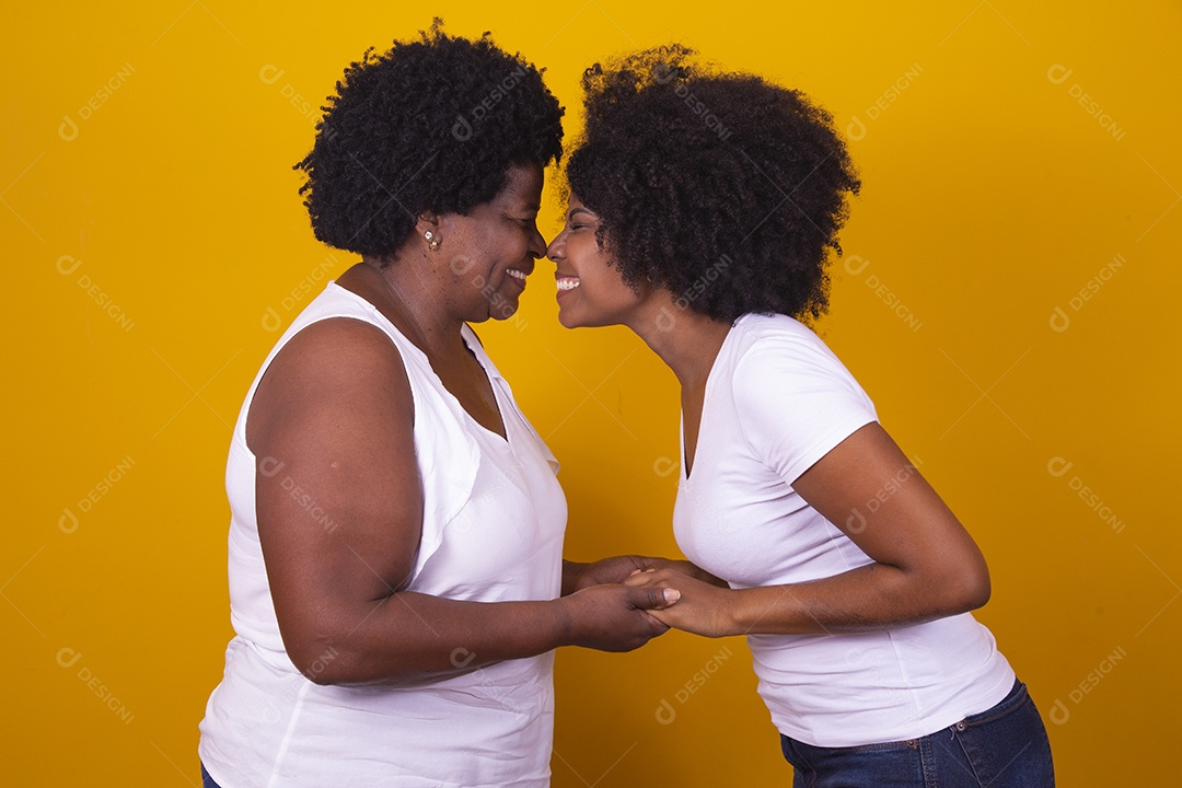 Mulheres negras mãe e filha vestidas com blusa branca com gestos de carinho