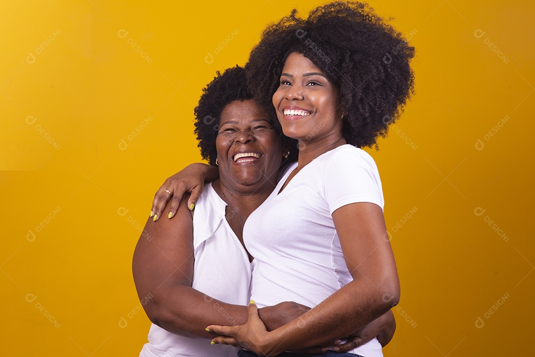 Mulheres negras mãe e filha vestidas com blusa branca abraçadas