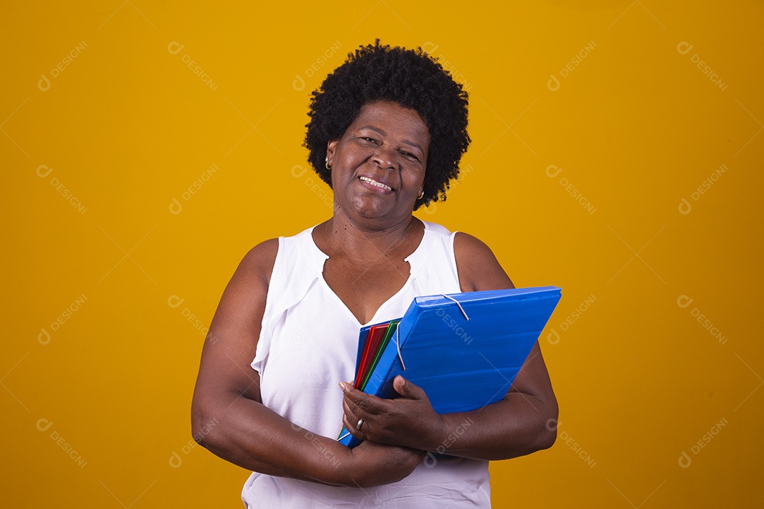 Mulher de meia idade usando blusa branca segurando cadernos coloridos