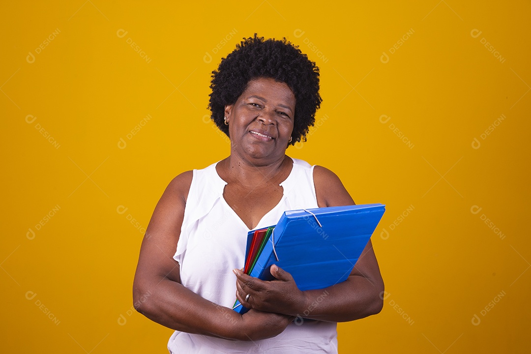 Mulher de meia idade usando blusa branca segurando cadernos coloridos