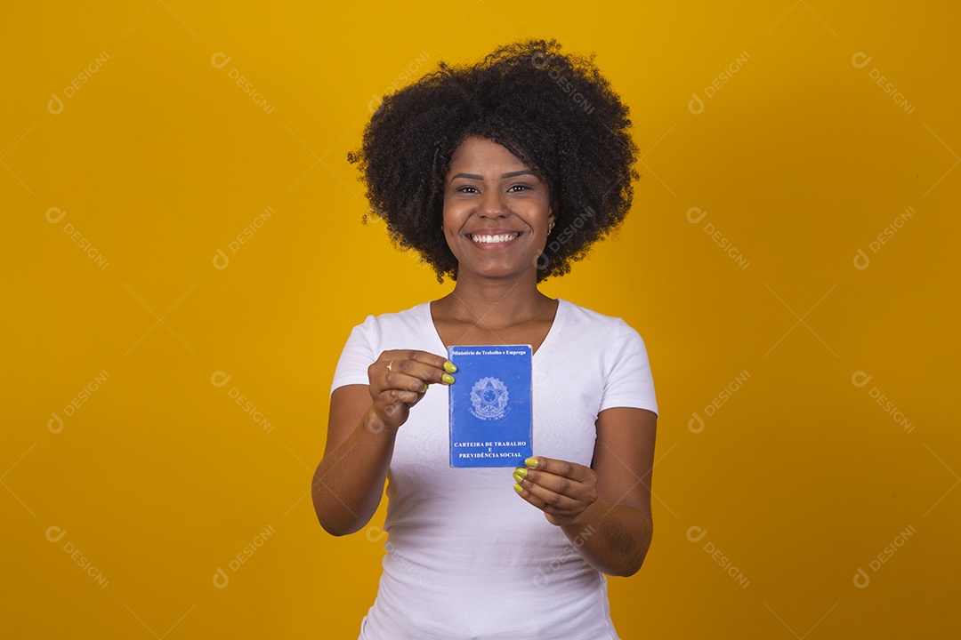 Mulher negra jovem vestindo blusa branca segurando uma carteira de trabalho