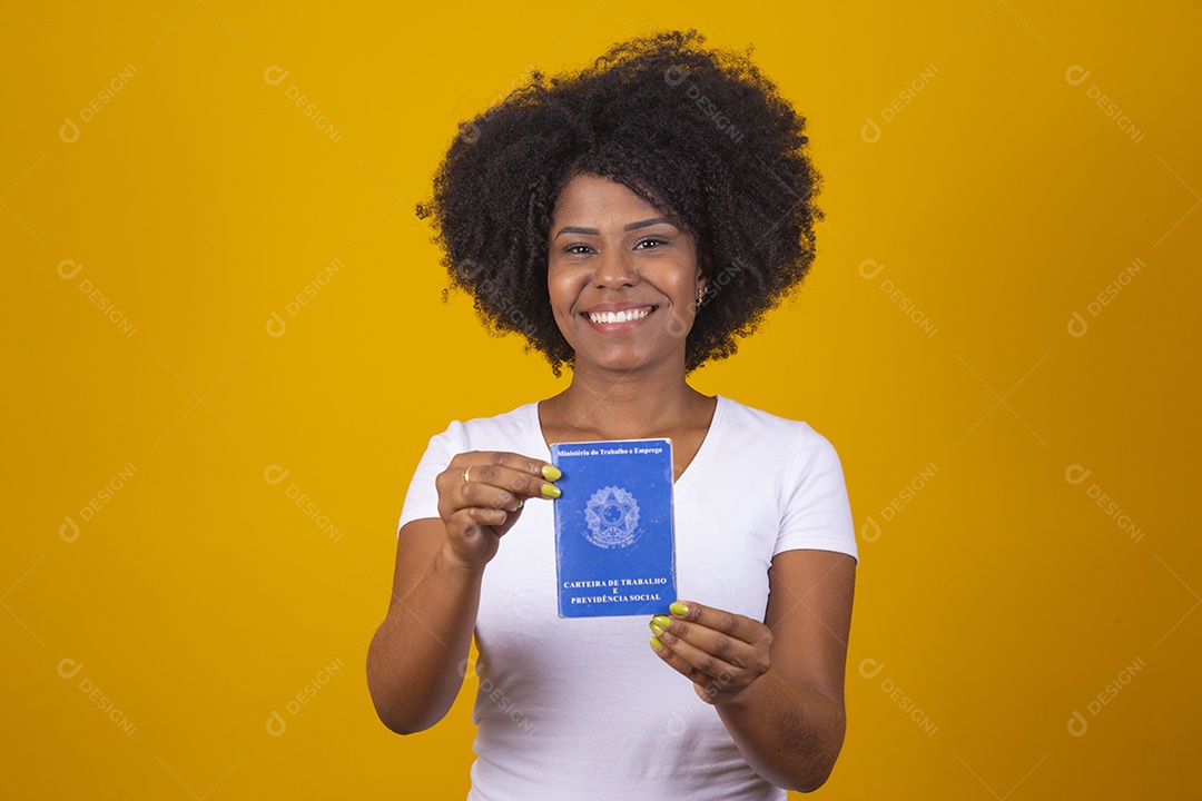 Mulher negra jovem vestindo blusa branca segurando uma carteira de trabalho