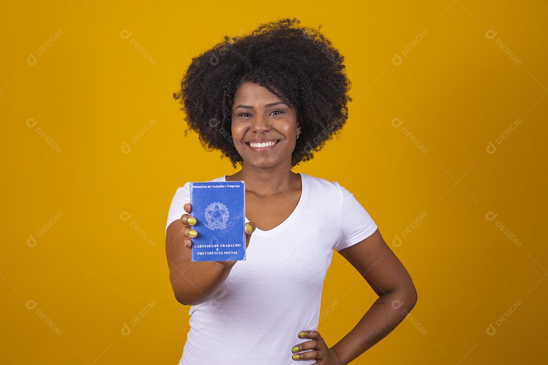 Mulher negra jovem vestindo blusa branca segurando uma carteira de trabalho