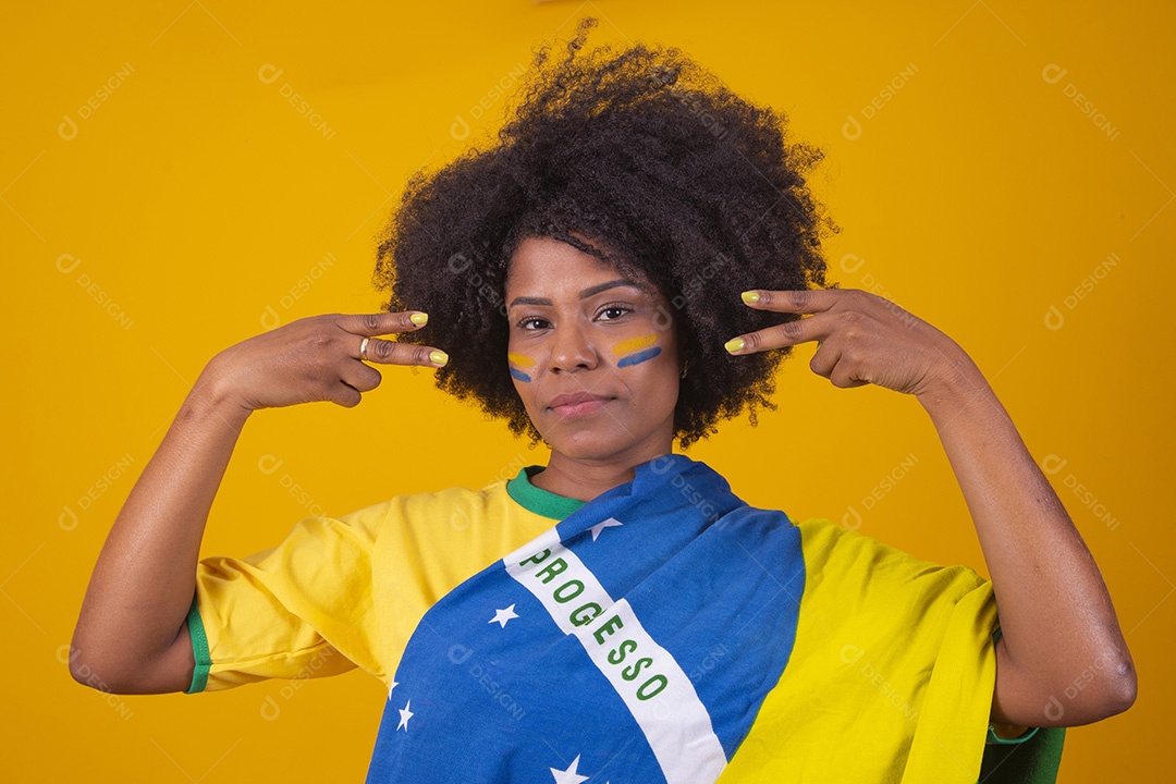 Mulher negra vestindo bandeira do Brasil com pinturas verde e amarela no rosto