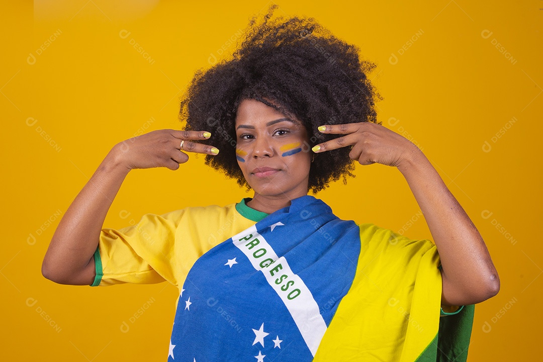 Mulher negra vestindo bandeira do Brasil com pinturas verde e amarela no rosto