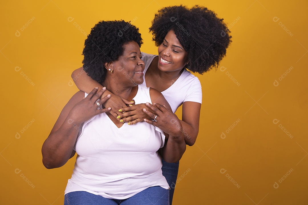 Filha abraçando sua mãe cabelos afro família