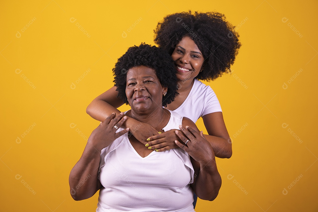 Filha abraçando sua mãe cabelos afro família