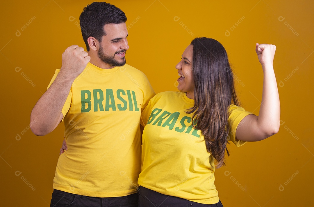 Casal jovens torcedores usando camisetas do brasil fundo isolado amarelo