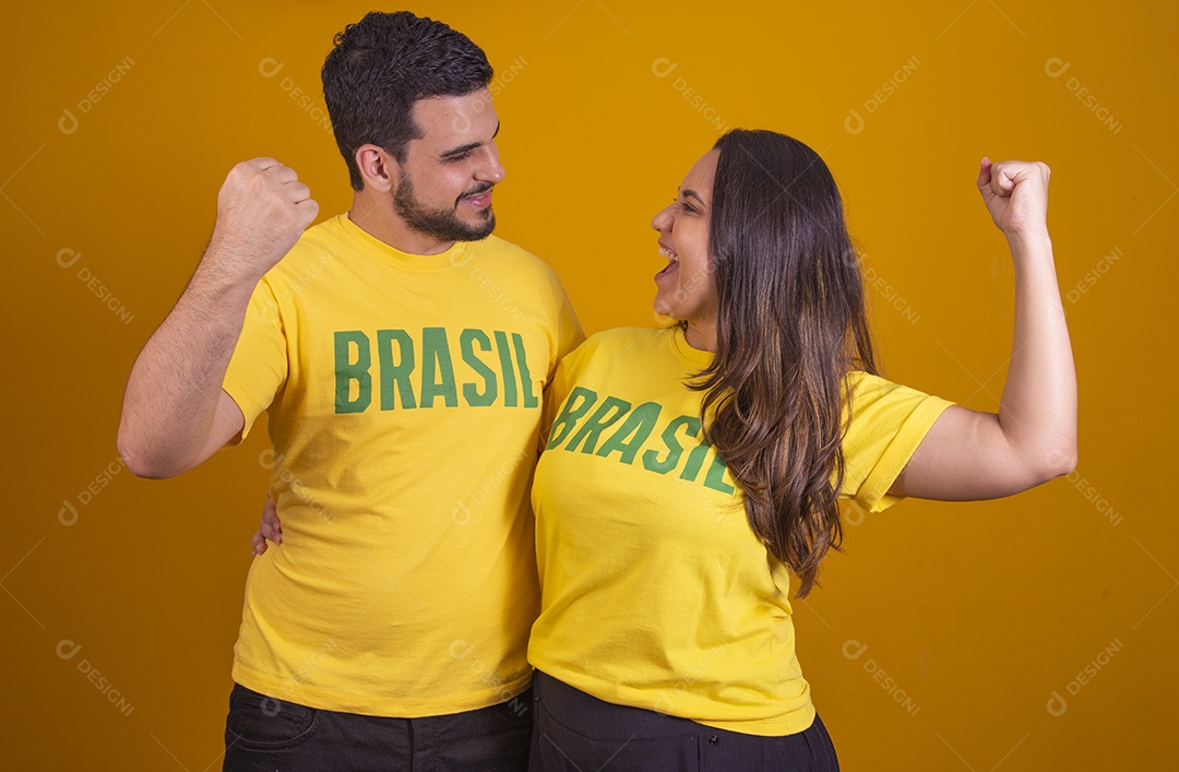 Casal jovens torcedores usando camisetas do brasil fundo isolado amarelo