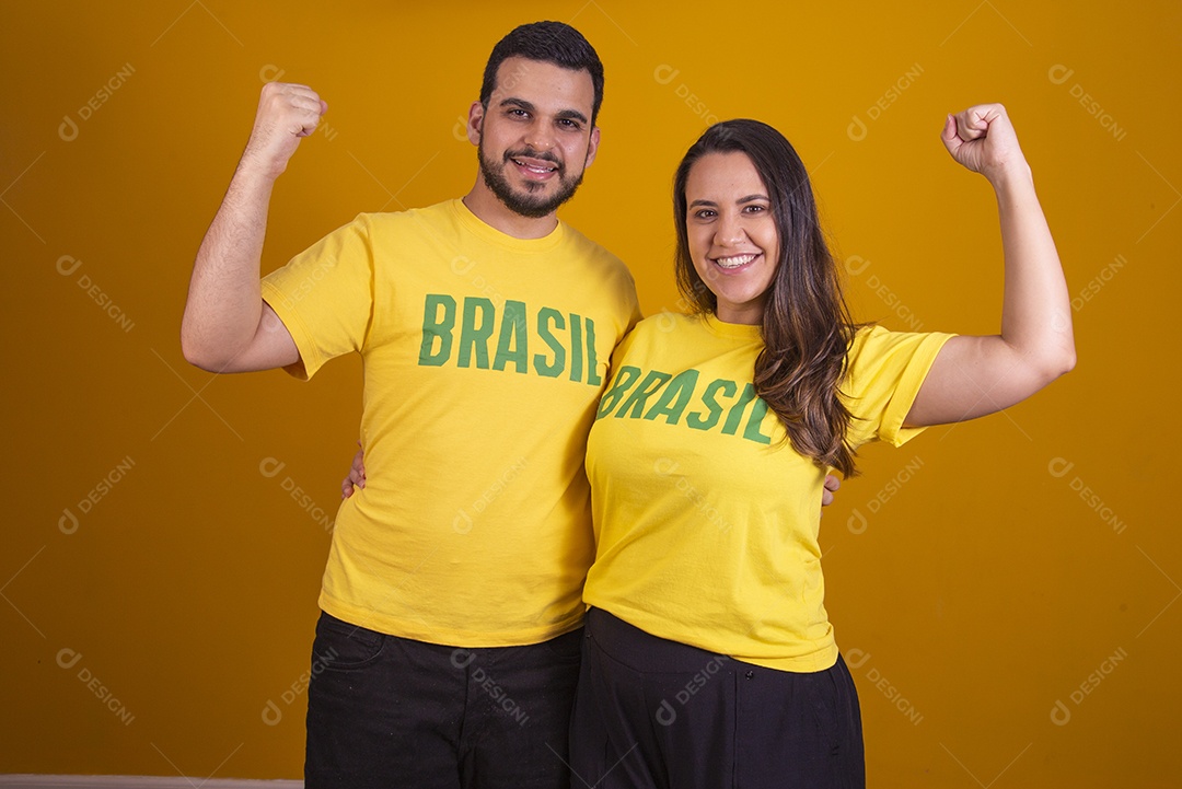 Casal jovens torcedores usando camisetas do brasil fundo isolado amarelo