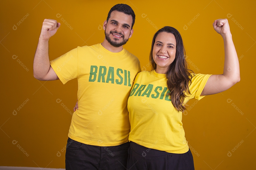 Casal jovens torcedores usando camisetas do brasil fundo isolado amarelo