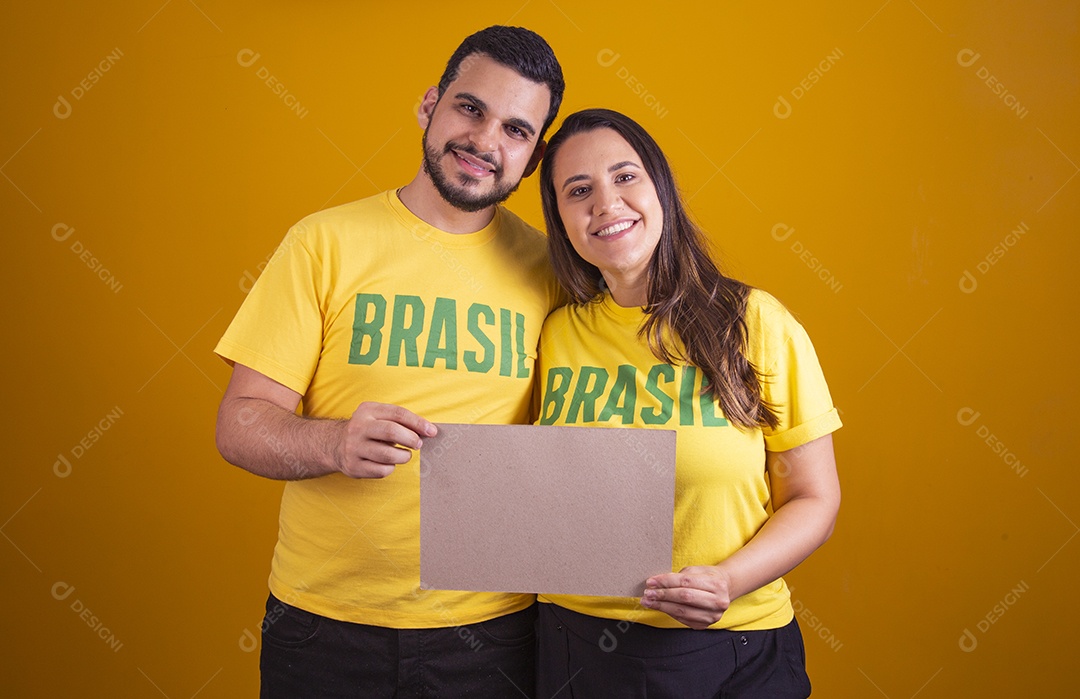 Casal jovens torcedores usando camisetas do brasil fundo isolado amarelo