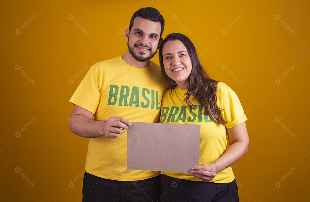 Casal jovens torcedores usando camisetas do brasil fundo isolado amarelo