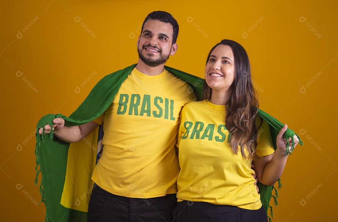 Casal jovens torcedores usando camisetas do brasil fundo isolado amarelo