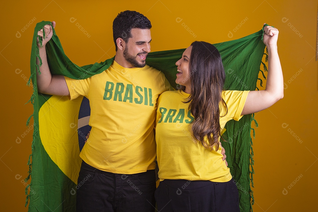 Casal jovens torcedores usando camisetas do brasil fundo isolado amarelo