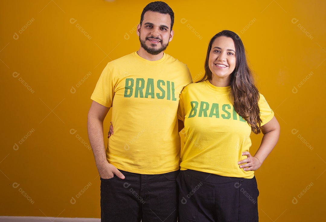 Casal jovens torcedores usando camisetas do brasil fundo isolado amarelo