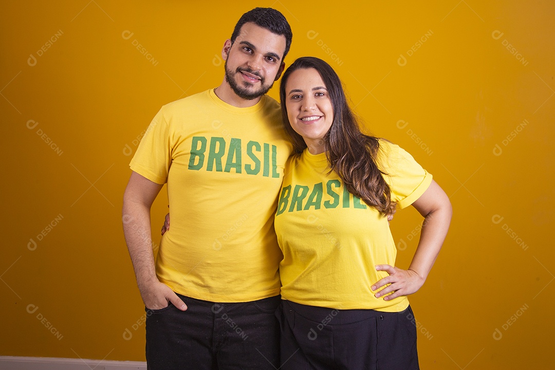 Casal jovens torcedores usando camisetas do brasil fundo isolado amarelo