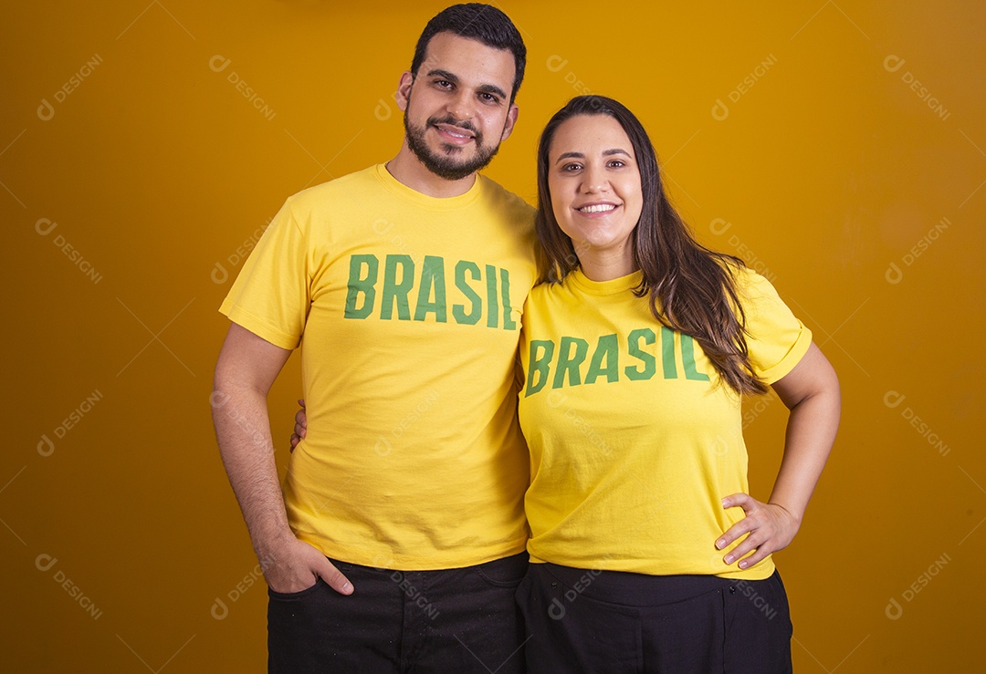 Casal jovens torcedores usando camisetas do brasil fundo isolado amarelo
