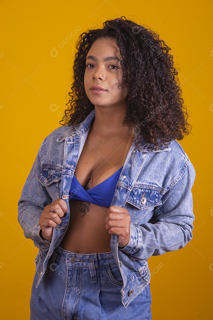 Linda mulher jovem cabelo cacheado sobre fundo isolado amarelo