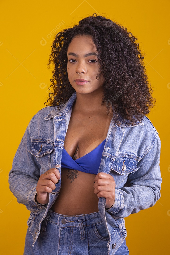 Linda mulher jovem cabelo cacheado sobre fundo isolado amarelo