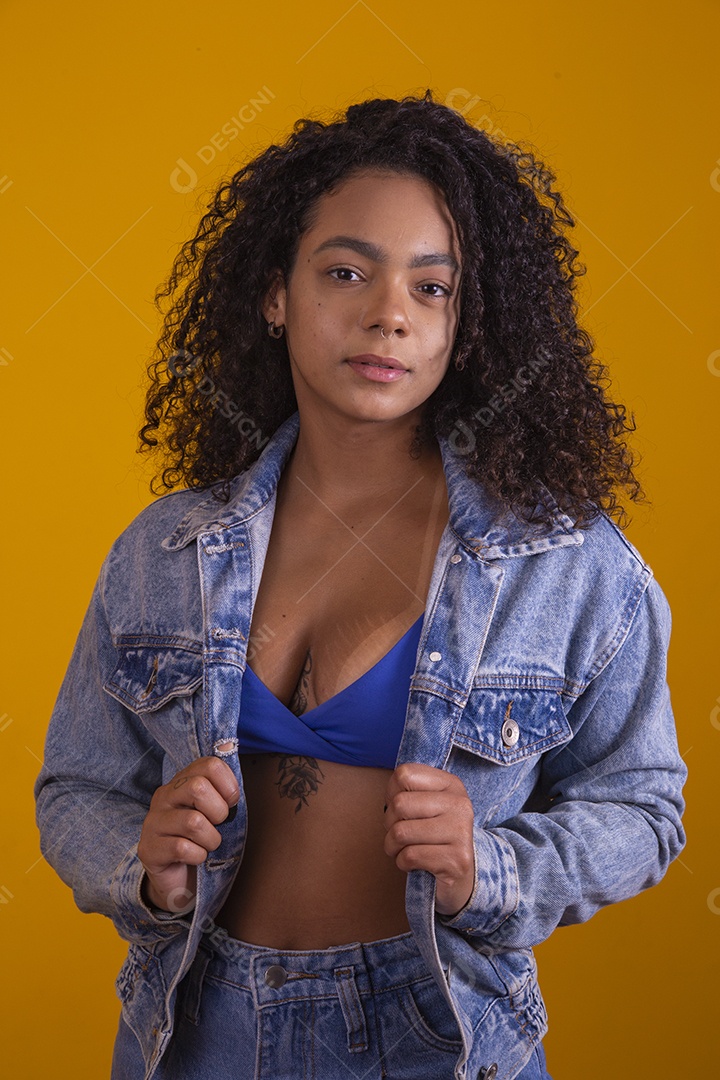 Linda mulher jovem cabelo cacheado sobre fundo isolado amarelo