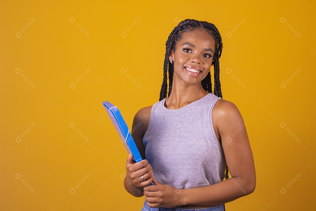 Linda mulher estudante segurando material escolar sobre fundo isolado amarelo