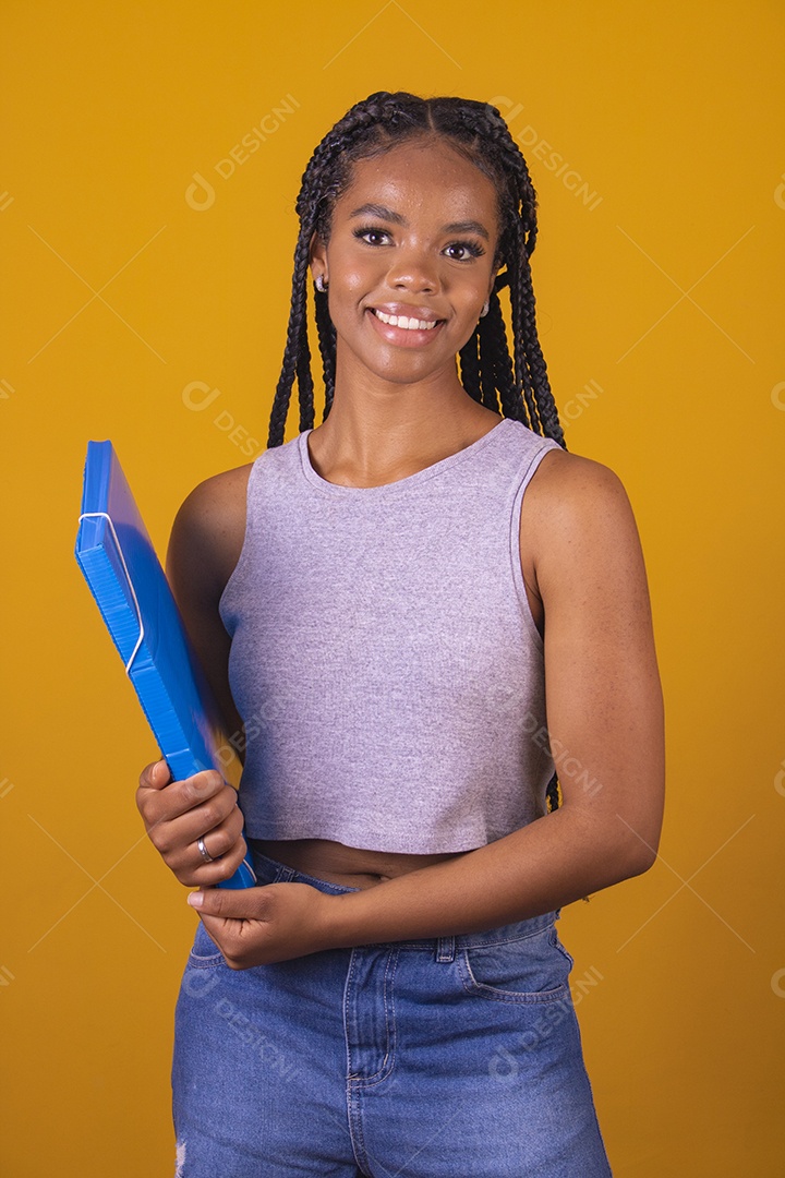 Linda mulher estudante segurando material escolar sobre fundo isolado amarelo