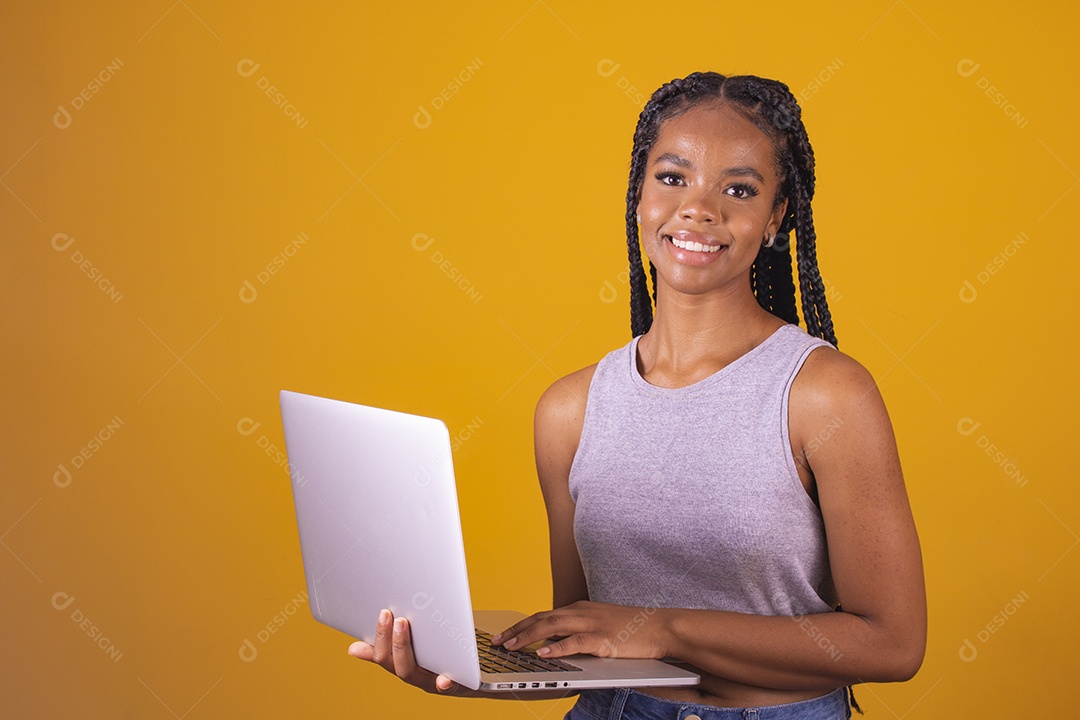 Mulher jovem segurando notebook laptop fundo isolado amarelo