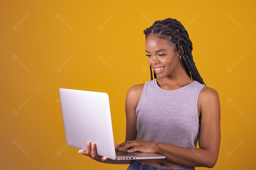 Mulher jovem segurando notebook laptop fundo isolado amarelo