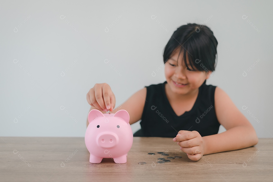 Menina asiática bonita colocando dinheiro no cofrinho para economizar dinheiro