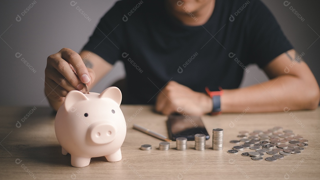 Empresário colocando uma moeda no cofrinho na mesa, doação