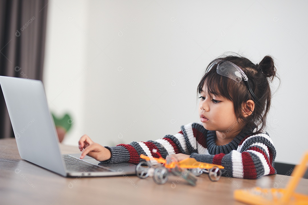 Inventive girl building robot cars at home