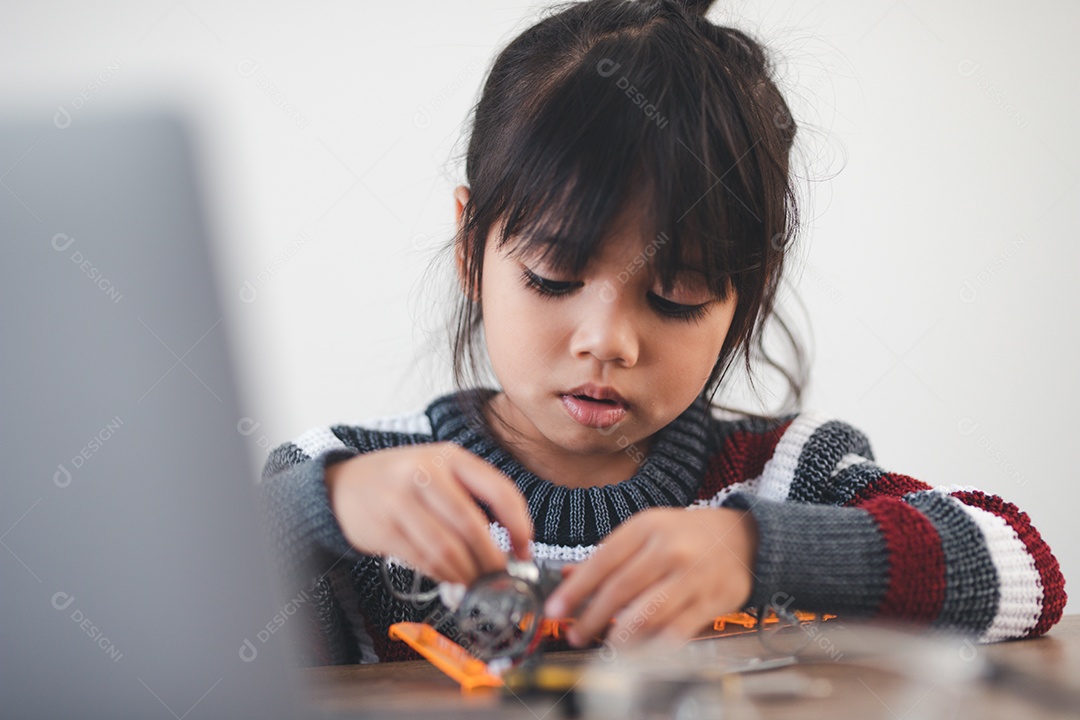 Inventive girl building robot cars at home
