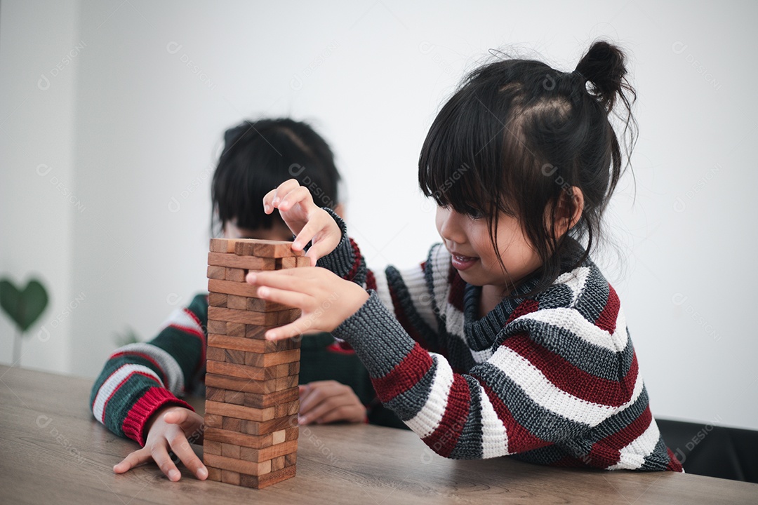 Alegre menina asiática brincando com blocos de madeira.