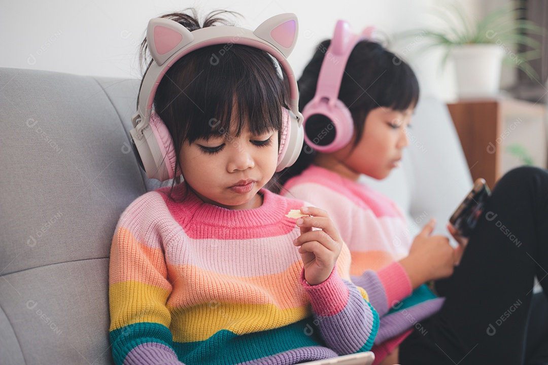 Garota de irmãos asiáticos navegando nas redes sociais e jogando