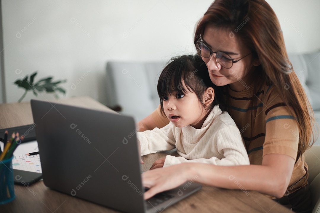Mãe trabalhando em home-office com filha no colo