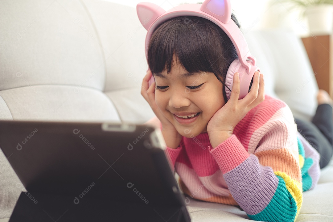 Menina asiática feliz ouvindo música na sala de estar