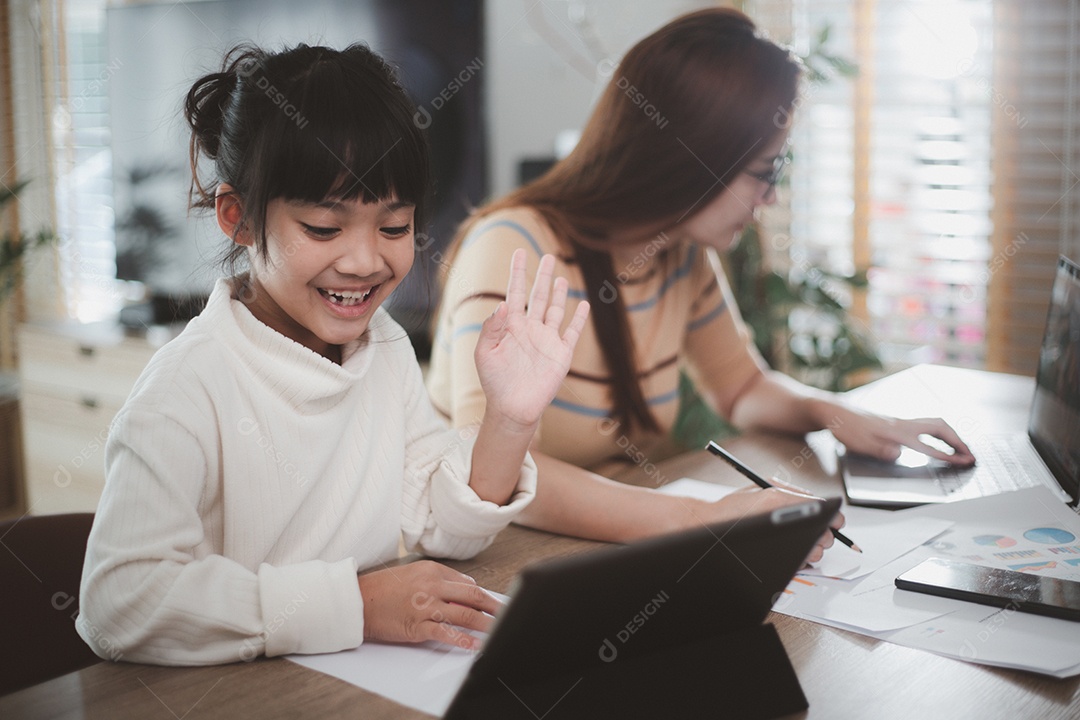 Mãe trabalhando em home-office com filha no colo